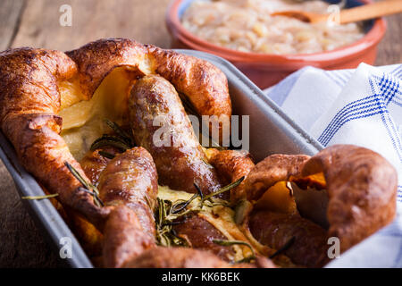 Gebackene Wurst in Yorkshire Pudding Teig und mit Zwiebel Sauce serviert, Kröte in der Bohrung Stockfoto