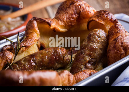 Gebackene Wurst in Yorkshire Pudding Teig und mit Zwiebel Sauce serviert, Kröte in der Bohrung Stockfoto