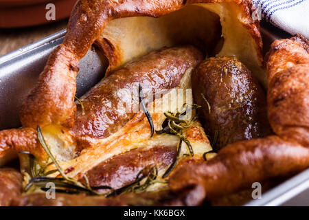 Gebackene Wurst in Yorkshire Pudding Teig und mit Zwiebel Sauce serviert, Kröte in der Bohrung Stockfoto