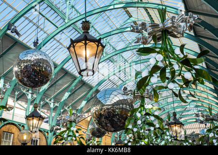 Riesige Kugeln und Mistel hängende Dekorationen zu Weihnachten am Covent Garden in London, UK feiern. Stockfoto