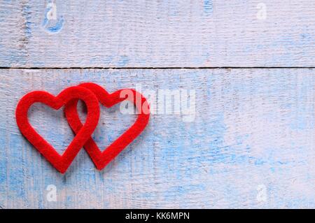 Zwei rote Herzen Stoff Holztisch. Stockfoto