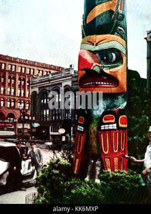 1933 - Vintage Farbfoto der gebürtigen indischen Totem Pole im Pioneer Square, Downtown Seattle. Ursprünglich aus der Tlingit Dorf Tongass. Auf der rechten Seite einen Mann gesehen, gibt es einen neuen Anstrich. Stockfoto