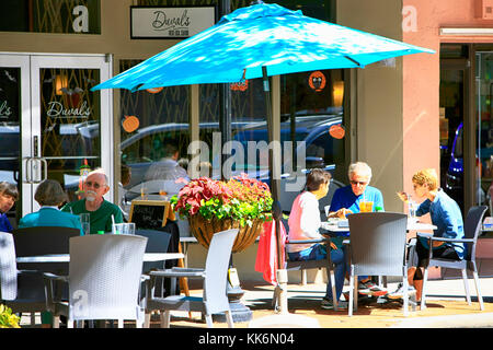 Leute, die ein Mittagessen in entspannter Atmosphäre vor einem Restaurant in der Innenstadt von Main Street, Sarasota FL, genießen Stockfoto