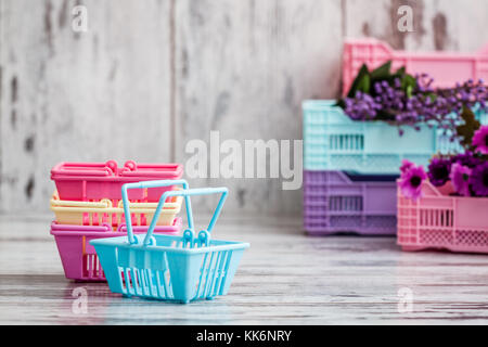 Bunte miniatur Warenkörbe auf weißem Holz- Hintergrund Stockfoto