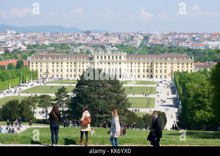 Wien, Österreich - Apr 30th, 2017: klassische Ansicht der berühmten Schloss Schönbrunn mit großem Parterre Garten mit Menschen zu Fuß an einem sonnigen Tag mit blauen Himmel und Wolken im Sommer. Der Palast ist eine ehemalige Kaiserliche 1441 - Zimmer Rokoko Sommerresidenz sissi Kaiserin Elisabeth von Österreich Stockfoto