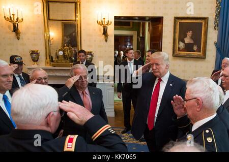 US-Präsident Donald Trump grüßt im Blauen Raum des Weißen Hauses am 23. Oktober 2017 in Washington, D.C. den pensionierten Kapitän der US-Armee Gary M. Rose und seinen vietnamesischen Veteranen „Battle Buddies“. Stockfoto