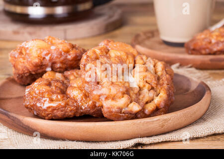 Nahaufnahme des verglasten Apple fritters auf einer Holzplatte Stockfoto