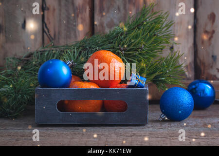 Mandarinen mit blau Weihnachtskugeln im Vintage box. getönt. Stockfoto