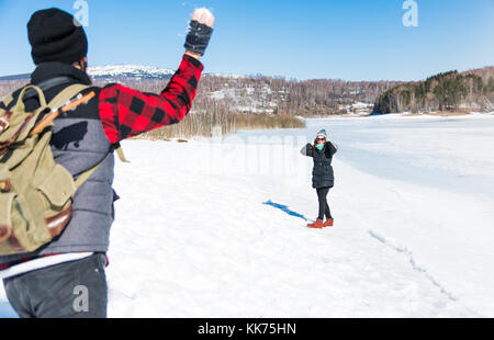 Paar Schneeball kämpfen und Spaß auf einem zugefrorenen See Stockfoto