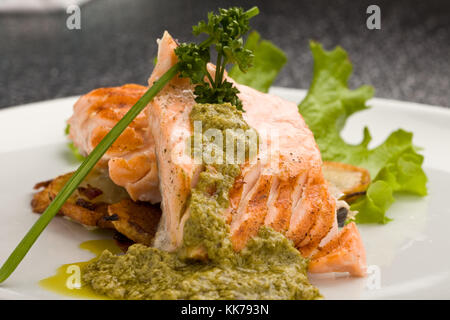 Foto von köstlichen gegrillten Lachs mit grünen Basilikumsauce und Gemüse Stockfoto