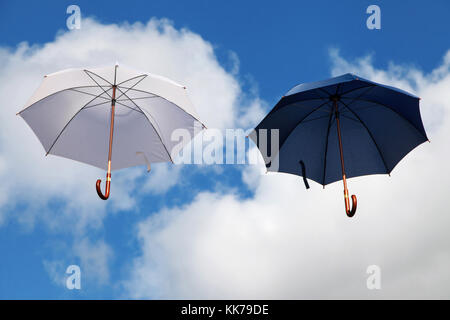 Zwei schwimmende Sonnenschirme in Weiß und Dunkelblau Stockfoto