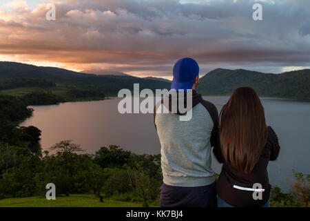 Junges Paar genießen den Sonnenuntergang Farben reflektieren die Wolken über Cote See in Costa Rica Stockfoto