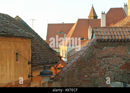 Alte traditionelle rumänische Vintage orange braun Häuser mit Gauben Dachfenster in den Augen entwickelten Form bei ziegeldächern Abends im Stadtzentrum. Stockfoto