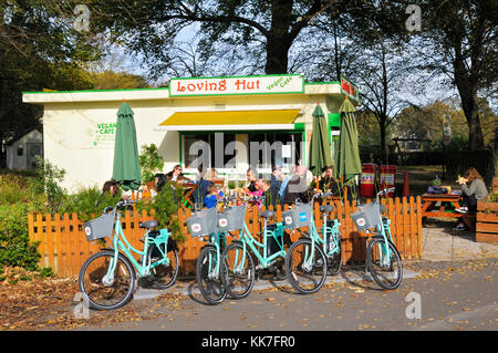 Menschen essen außerhalb der liebevollen Hütte Veganes Cafe in Brighton, East Sussex, England, Großbritannien Stockfoto