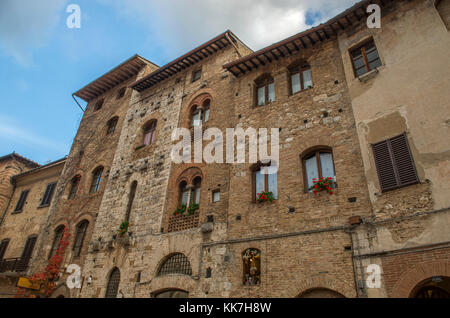 Alte Backsteingebäude mit Blumen an den Fenstern Stockfoto