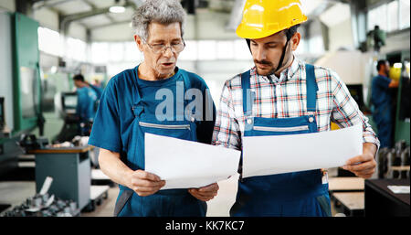 Team von Ingenieuren mit Diskussion In Fabrik Stockfoto