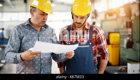 Team von Ingenieuren mit Diskussion In Fabrik Stockfoto