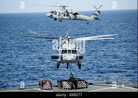 MH-60S Sea Hawk Hubschraubern von der Insel Ritter von Hubschrauber Meer Combat Squadron HSC 25 heben die Lieferungen aus den fantail der Military Sealift Command s Dry Cargo und Munition ship USNS Amelia Earhart T-AKE 6 vor auf dem Flugzeugträger USS George Washington CVN 73, Pazifischer Ozean, 2012. Bild mit freundlicher Genehmigung von Massenkommunikation Specialist 3. Klasse Paul Kelly/US Navy. Stockfoto