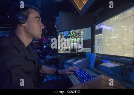 Lt. jg Michael Cornish, von Omaha, Neb, steht in der combat Information Center an Bord der geführte-missile Cruiser USS Normandy CG 60 während ein Luft-Verteidigung Übung als Teil der gemeinsamen Übung Malabar 2015, USA 7.Flotte Bereich der Operationen. Bild mit freundlicher Genehmigung von Massenkommunikation Specialist 3. Klasse Justin R. DiNiro/US Navy, 2015. Stockfoto