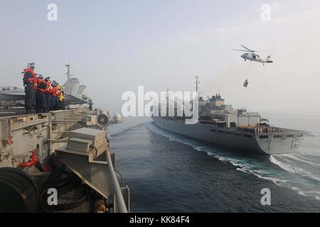 Matrosen an Bord der Flugzeugträger USS Theodore Roosevelt CVN 71 bereiten Sie eine im Gange Auffüllung mit dem Militär Sealift Command schnell Combat support ship USNS Arktis T-AOE8, Arabischen Golf zu führen. Bild mit freundlicher Genehmigung von Massenkommunikation Specialist 2. Klasse J. Michael Drew/US Navy, 2015. Stockfoto