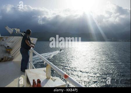 Deck Mechaniker Donald Rodriguez, ein Military Sealift Command civil service Mariner, Uhren wie die Hospital Ship USNS Comfort T-AH 20 in Roseau, Dominica im Verlauf der weiteren Versprechen 2015, Roseau, Dominica ankommt. Bild mit freundlicher Genehmigung von Massenkommunikation Specialist 2. Klasse Brittney Cannady/US Navy, 2015. Stockfoto