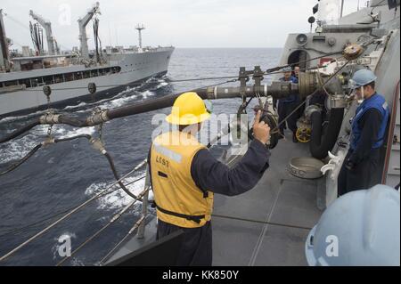 Matrosen an Bord des Littoral Combat Ship USS Fort Worth verbinden eine Kraftstoffleitung während einer Auffüllung-auf-see Übung mit dem Military Sealift Command flotte Auffüllung öler USNS Pecos T-AO 197 und der Republik Singapur Marine als Teil der Zusammenarbeit flott Bereitschaft und Weiterbildung CARAT Singapur 2015, South China Sea. Bild mit freundlicher Genehmigung von Massenkommunikation Specialist 2. Klasse Joe Bischof/US Navy, 2015. Stockfoto