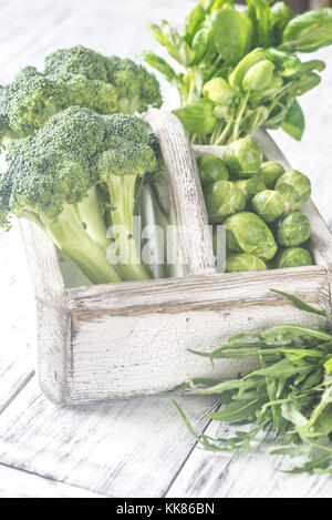 Grünes Gemüse mit Kräutern in den hölzernen Warenkorb Stockfoto