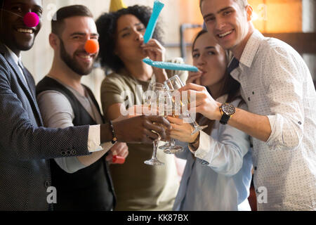 Multirassischen junge Menschen anstossen Trillerpfeifen blasen celeb Stockfoto