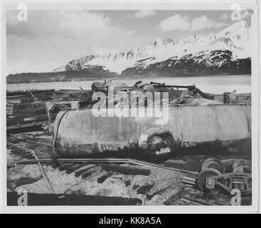 Ein Foto, das zeigt ein Blick auf die Alaska Railroad Yard in Seward, Alaska, wie es nach dem Erdbeben von 1964, die Eisenbahnschienen, Zug Autos erschienen, und Gebäude, die von einem Tsunami und Feuer, führte durch das Erdbeben zerstört wurden große Teile der Stadt zerstört wurden, wenn mehrere Tsunamis eine weitere Ausbreitung des brennenden Öls über es, die 92 Erdbeben in Prince William Sound entstanden und ist der zweitgrößte Erdbeben jemals verzeichneten, Seward, Alaska, 1964. Stockfoto