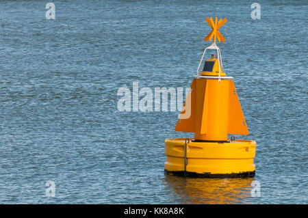 Eine gelbe Boje schwimmt auf der Wasseroberfläche im Hafen von Rotterdam in den Niederlanden. Stockfoto