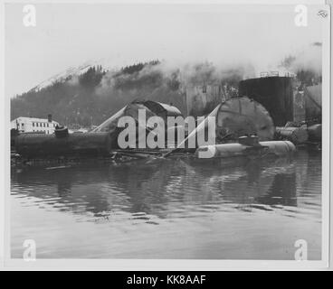 Ein Foto von der Beschädigung der Alaska Railroad Yard und Texaco bulk Pflanze gemacht nach Alaska Erdbeben 1964, großen Tanks und Wagen im Wasser nach der durch das Erdbeben selbst und die daraus resultierenden Tsunami zerstört zu sehen ist, große Teile der Stadt zerstört wurden, wenn mehrere Tsunamis eine weitere Ausbreitung des brennenden Öls über es, die 92 Erdbeben in Prince William Sound entstanden und ist der zweitgrößte Erdbeben jemals verzeichneten, Seward, Alaska, 1964. Stockfoto