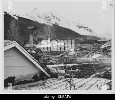 Ein Foto, das Schäden an Seward als Ergebnis der Alaska Erdbeben 1964, das abgebildete Gebiet ist ein trümmerfeld von den direkten Auswirkungen des Erdbebens erstellt und die daraus resultierende tsunamis, die auch eine weitere Ausbreitung des brennenden Öls über die ganze Stadt, ein Boot und die Dächer der Häuser werden gesehen, auf dem Boden sitzend, die 92 Erdbeben in Prince William Sound entstanden und ist der zweitgrößte Erdbeben jemals verzeichneten, Seward, Alaska, 1964. Stockfoto