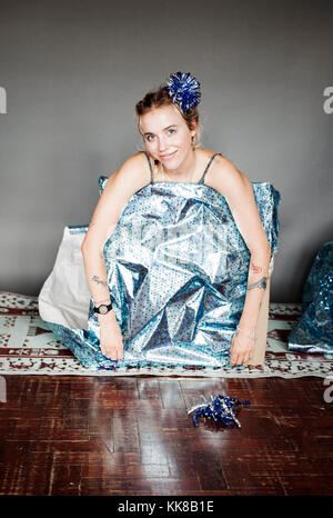 Junge hübsche Frau tätowiert wie in Karton Geschenk in blau Papier mit Model Release, London verpackte Geschenk verpackt, 18/06/2017 Stockfoto