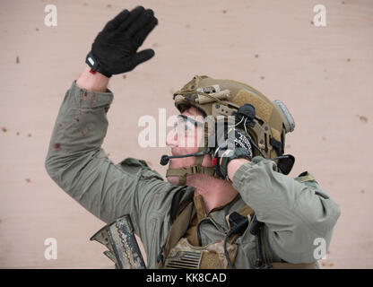 Eine Alaska Air National Guard pararescueman mit der 212Th Rescue Squadron bei einem ankommenden Hubschrauber kommuniziert während der Durchführung von medizinischen Evakuierungen während einer Messe- und Unfallversicherung Schulungsveranstaltung an Joint Base Elmendorf-Richardson, Alaska, Nov. 21, 2017. Während der Übung, die Rettung Betreiber befindet, bewertet, behandelt und zahlreiche Opfer evakuiert beim Einkuppeln und die Beseitigung mehrerer Angriffe von oppositionellen Kräften. Die Hubschrauber waren, die von den 1st Bataillon der Alaska Army National Guard, 207 Aviation Regiment. (U.S. Air Force Foto von Alejandro Peña) Stockfoto