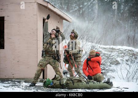 Alaska Air National Guard pararescuemen mit der 212Th Rescue Squadron Vorbereiten einer simulierten Opfer eines Warten auf Hubschrauber an der Hebevorrichtung, während sie sich in einer Masse teilnehmenden Schaden-unfall-schulungsveranstaltung an Joint Base Elmendorf-Richardson, Alaska, Nov. 21, 2017. Während der Übung, die Rettung Betreiber befindet, bewertet, behandelt und zahlreiche Opfer evakuiert beim Einkuppeln und die Beseitigung mehrerer Angriffe von oppositionellen Kräften. (U.S. Air Force Foto von Alejandro Peña) Stockfoto