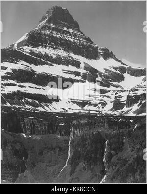 Schwarz-weiß Foto, volle Sicht auf den schneebedeckten Berg, einschließlich Bereich unter Timberline, Untertiteln' im Glacier National Park', von Ansel Adams, von Fotografien von Nationalparks und Monumente, Montana, United States, 1941. Stockfoto