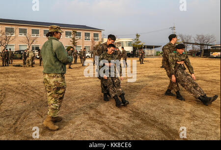 Soldaten, die in der 5. Republik Korea Armee Infanterie Division zieht simulierten Patienten während ihrer Bekämpfung Life Savers Ausbildung bei Yeoncheon, Südkorea, Nov. 22, 2017. Die 210Th Field Artillery Brigade Mediziner durchgeführt eine erste Round Robin medizinische Ausbildung 5 ROKA-ID in das Verständnis der medizinischen Behandlung und die Bekämpfung der Bereitschaft zu helfen. (U.S. Armee Foto von Sgt. Michelle U. Blesam, 210Th FA BDE PAO) Stockfoto