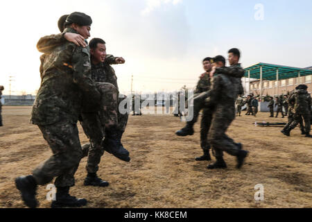 Soldaten in der 5. Republik Korea Armee Infanterie Division verhalten Schlacht Buddy zugewiesen, trägt während ihrer Bekämpfung Life Savers Ausbildung bei Yeoncheon, Südkorea, Nov. 22, 2017. Die 210Th Field Artillery Brigade Mediziner durchgeführt eine erste Round Robin medizinische Ausbildung 5 ROKA-ID in das Verständnis der medizinischen Behandlung und die Bekämpfung der Bereitschaft zu helfen. (U.S. Armee Foto von Sgt. Michelle U. Blesam, 210Th FA BDE PAO) Stockfoto