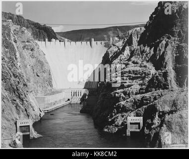 Ein schwarz-weiß Foto der Hoover Dam, Gebäuden, die Teil des Dammes und Jet-Tore im Vordergrund sichtbar sind, den Bau des Hoover Dam 1936 abgeschlossen wurde, das Bild stammt aus einer Serie von Fotografien bekannt als Wandbild Projekt von Ansel Adams, er durch den National Park Service wurde 1941 beauftragt, eine fotografische Wandbild für das Ministerium des Innern in Washington DC zu erstellen, wird das Projekt zu einem Ende kam wegen des Zweiten Weltkrieges, United States, 1941. Stockfoto