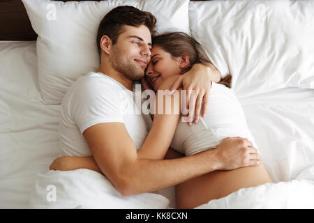 Bild von fröhlichen schwangere Frau zuhause zu Hause liegt im Bett mit ihrem stattlichen schöner Mann. Stockfoto