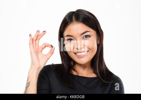 Foto der glückliche junge asiatische Dame, die auf weißem Hintergrund. Suche Kameras okay Geste. Stockfoto