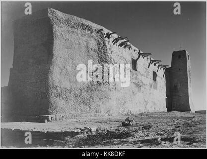 Eine schwarze und weiße Fassade Foto von San Estevan del Rey Mission Church, das Adobe Gebäude im 17. Jahrhundert gebaut wurde, Holzbalken, die die Struktur für das Dach schaffen ragen aus der Seite werden kann, ein Kreuz auf dem Turm an der Ecke steht, das Bild stammt aus einer Serie von Fotografien bekannt als Wandbild Projekt von Ansel Adams, er durch den National Park Service wurde 1941 beauftragt, eine fotografische Wandbild für das Ministerium des Innern in Washington DC zu erstellen, wird das Projekt zu einem Ende wegen des Zweiten Weltkrieges kam, die Kirche ist Teil der Acoma Pueblo und hat Inha. Stockfoto