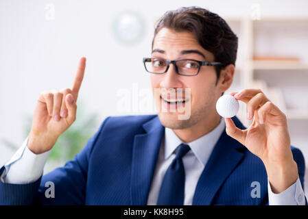 Junge Unternehmer mit Golf ball Arbeiten im Büro Stockfoto