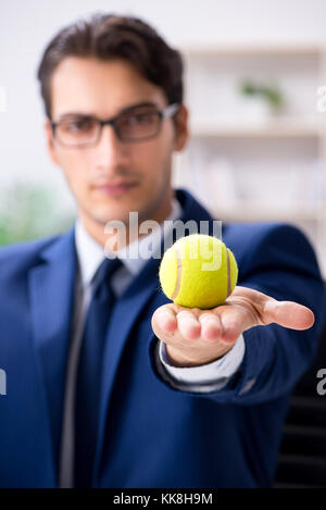 Junge Unternehmer mit Tennis ball Arbeiten im Büro Stockfoto