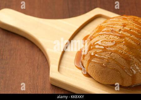 Brot mit Honig beträufelt auf Holzbrett closeup Stockfoto