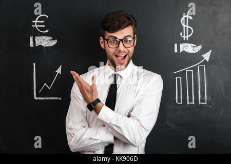 Gerne erfolgreicher Geschäftsmann in Weiß shirt finanzielle Regelung, auf schwarzen Tafel isoliert Stockfoto