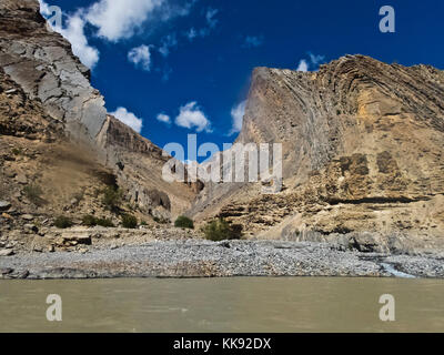 Geologische Felsformation erhebt sich über dem STUMPFEN FLUSS - ZANSKAR, LADAKH, INDIEN Stockfoto