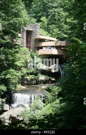 Ein Foto von der Außenseite des Hauses als Fallingwater, eine Gruppe von Touristen stehen auf einem Balkon mit Blick auf das Wasser, die laufen unter und rund um das Haus fällt, fallende Wasser im Jahr 1935 wurde von Frank Lloyd Wright gebaut, es gilt weithin als ein bedeutendes Stück Architektur zu sein, es war, als ein Nationales Historisches Wahrzeichen in 1966 ausgewiesenen, Mill Run, Pennsylvania, 2014. Stockfoto