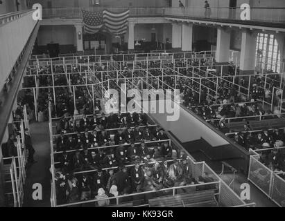 Schwarz-weiß Foto, die Stifte an der Ellis Island Registry Zimmer (oder Große Halle), die alle mit Immigranten gefüllt, von Edwin Levick, Ellis Island, New York, 1907. Von der New York Public Library. Stockfoto