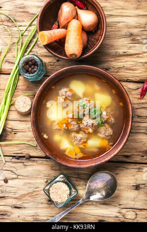 Fleisch Suppe in einem Ton Teller auf einem alten hölzernen Hintergrund Stockfoto